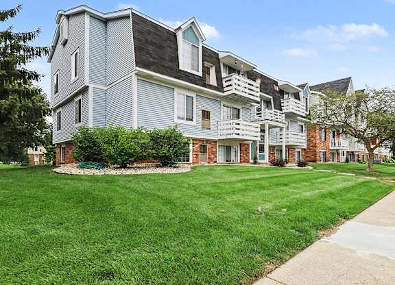 A large grey building with a red door in the front at Walnut Trail Apartments, Michigan