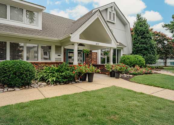 A house with a white front porch and a green lawn at WaterFront Apartments, Virginia Beach, 23453