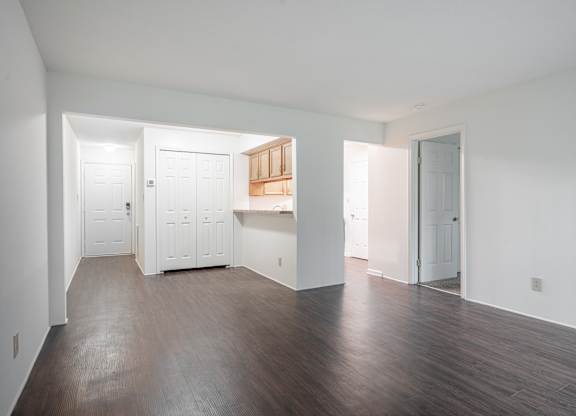 A room with white walls and wooden floors with a kitchen area in the middle at WaterFront Apartments, Virginia Beach, 23453