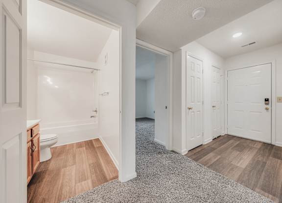 A white bathroom with a toilet and a sink at WaterFront Apartments, Virginia Beach, 23453