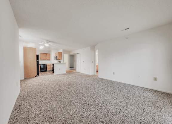 A spacious room with a grey carpet and white walls at WaterFront Apartments, Virginia Beach, 23453