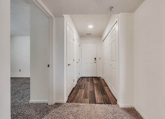 A long hallway with white walls and wood floors at WaterFront Apartments, Virginia Beach, 23453