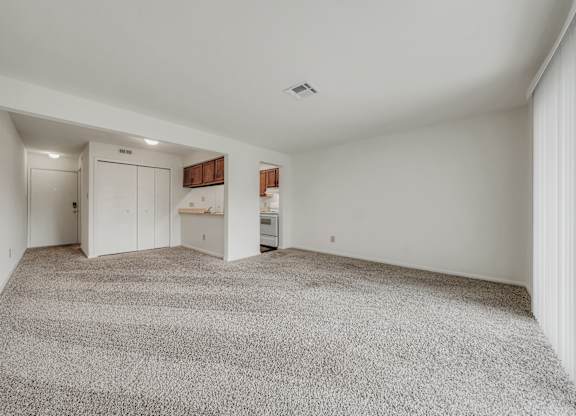 A spacious room with a grey carpet and white walls at WaterFront Apartments, Virginia Beach, 23453