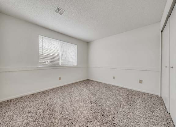 A room with a carpeted floor and a window with blinds at WaterFront Apartments, Virginia Beach, 23453