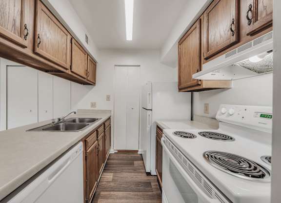 A kitchen with white appliances and wooden cabinets at WaterFront Apartments, Virginia Beach, 23453