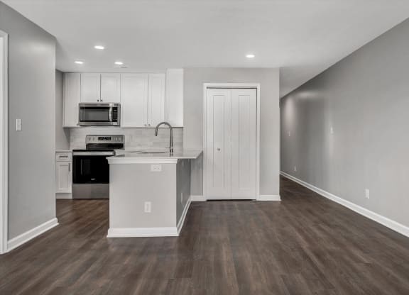 Living room and kitchen with white cabinets and a counter top at WaterFront Apartments, Virginia Beach, VA, 23453