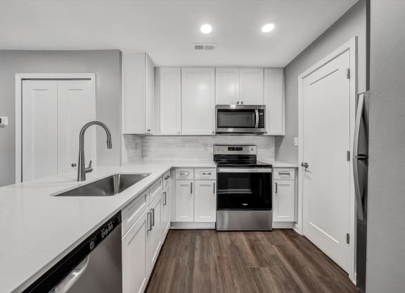 Kitchen with white cabinets and stainless steel appliances at WaterFront Apartments, Virginia, 23453