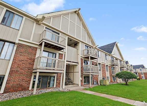 Apartment building with balconies and a green lawn in front at Waverly Park Apartments, Lansing
