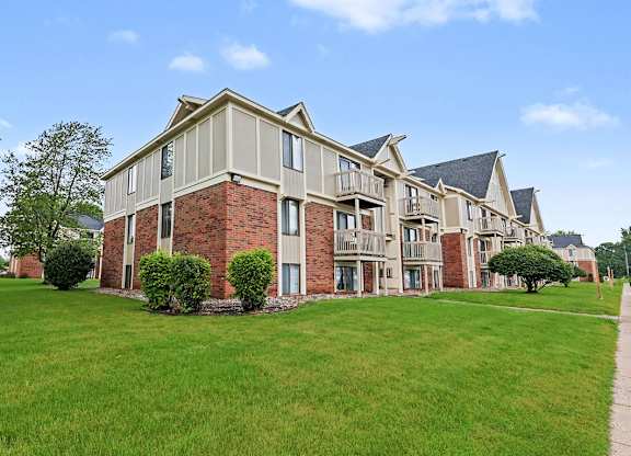 A large brick building with balconies on the second and third floors at Waverly Park Apartments, Lansing