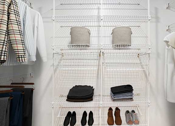 A walk in closet with wardrobe organizers at West Hampton Park Apartments in Elkhorn, NE 68022
