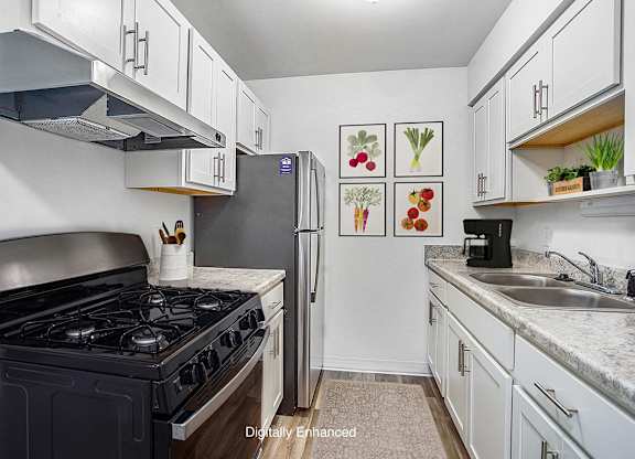 An upgraded kitchen with white cabinets and stainless steel appliances at Wingate Apartments, Michigan