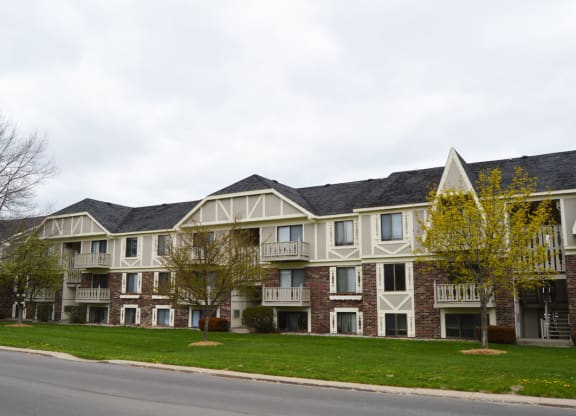 A brick apartment building with green grass in front at Wingate Apartments, Kentwood, Michigan