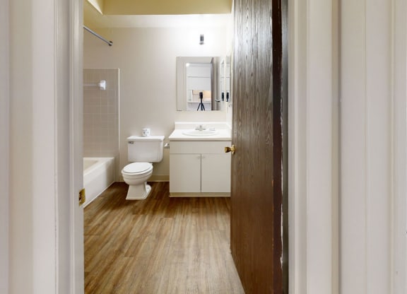 bathroom with a toilet and a sink  at Wood Creek Apartments, Kenosha, WI