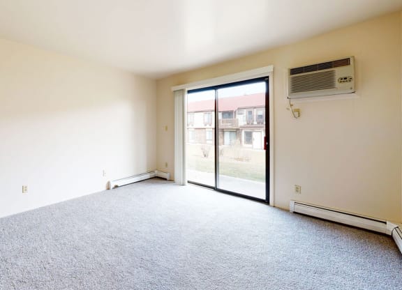 living room with a glass door to a patio  at Wood Creek Apartments, Kenosha