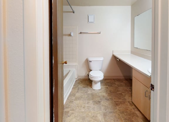 a bathroom with a toilet and a tub and a sink  at Wood Creek Apartments, Kenosha, 53144