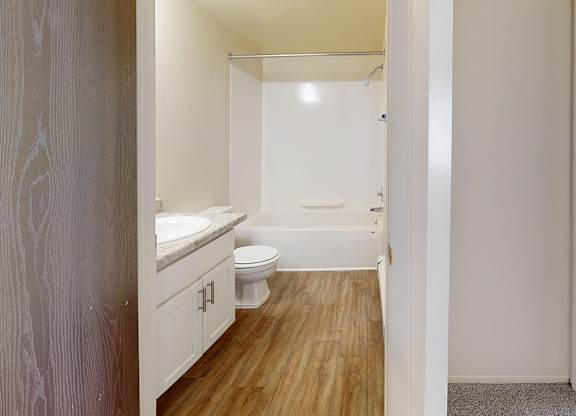 A bathroom with a toilet, sink, and bathtub at Wood Creek Apartments, Kenosha, WI, 53144