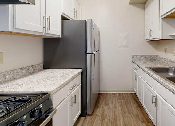 An upgraded kitchen with white cabinets and stainless steel appliances at Wood Creek Apartments, Kenosha, WI, 53144