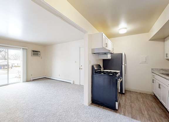A kitchen and living room with access to a private patio at Wood Creek Apartments, Kenosha, WI, 53144