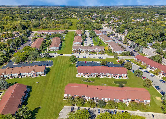A drone view of an apartment community with buildings and green lawns at Wood Creek Apartments, Wisconsin