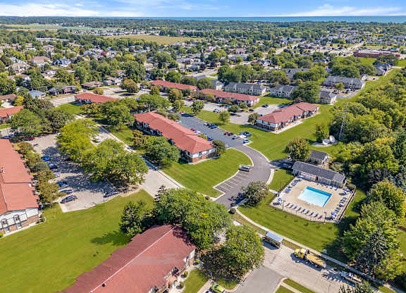 A bird's eye view of an apartment community with buildings and a swimming pool at Wood Creek Apartments, Wisconsin