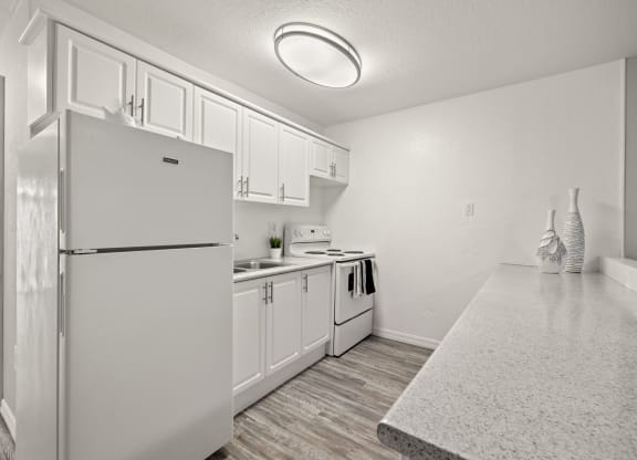 the kitchen of our studio apartment atrium with white appliances and white cabinets