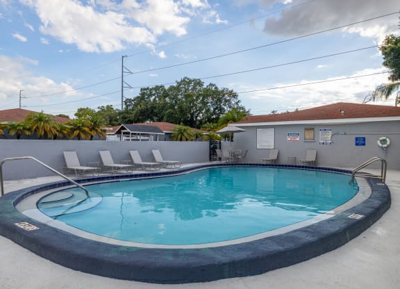 a swimming pool with a house in the background