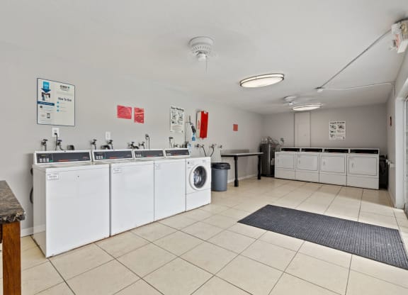 a kitchen with white appliances and counters and a washer and dryer
