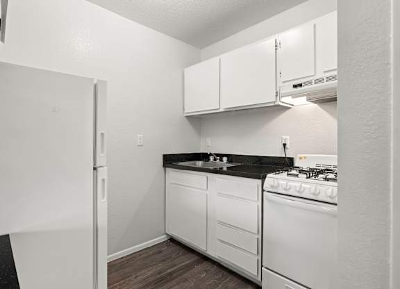 A kitchen with white appliances and cabinets.