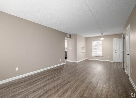 A room with wooden flooring and white walls.
