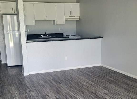 A kitchen with a white counter and a grey floor.