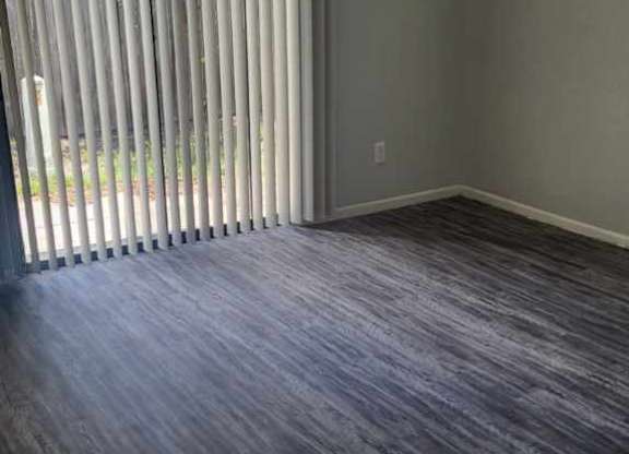 A room with a sliding door and wood flooring.