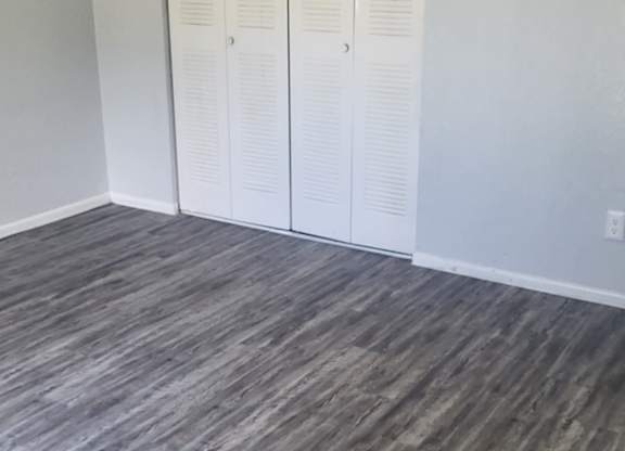 A room with a grey floor and a white closet.