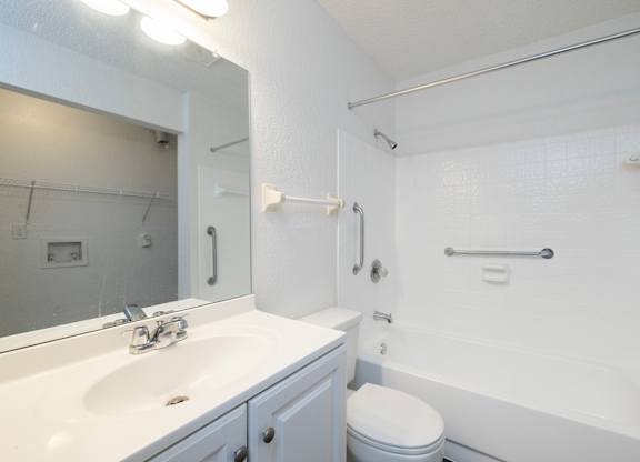 A white bathroom with a toilet, sink, and bathtub.