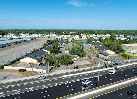 A view of a highway with cars driving on it and buildings in the background.
