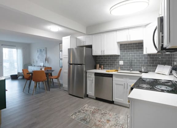 A modern kitchen with a dining table and chairs.