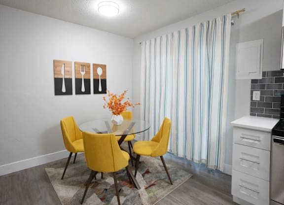 A kitchen with a table and chairs.