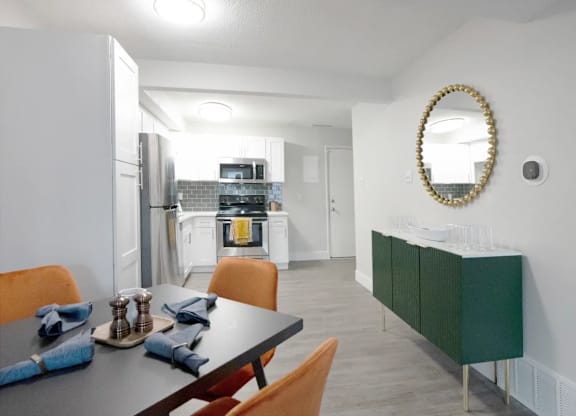 A modern kitchen with a dining table set for two.