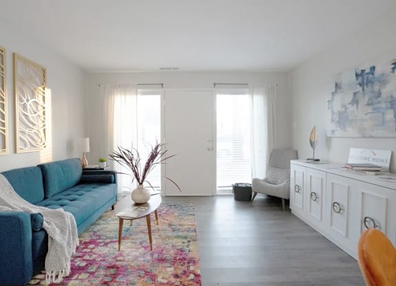 A living room with a blue couch and a white cabinet.