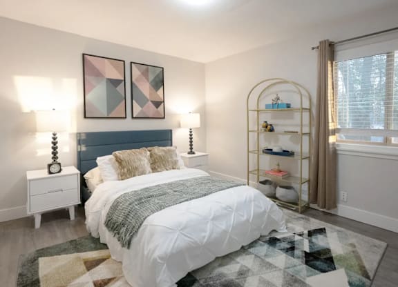 A bedroom with a large bed and a shelf with shoes on it.