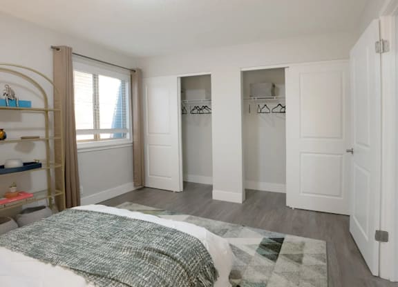 A bedroom with a bed, a wardrobe, and a shelf.