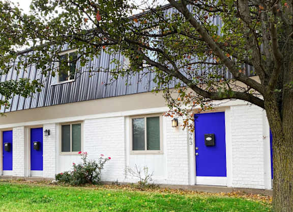 A white house with blue doors and windows.