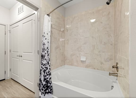 a bathroom with a tub and a shower and a door at Pearce at Pavilion Luxury Apartments, Riverview, FL