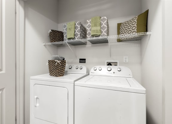 a white washer and dryer in a laundry room with a shelf above it at Pavilion Luxury Apartments, Riverview, 33578