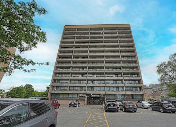 A parking lot with cars and a large building in the background.