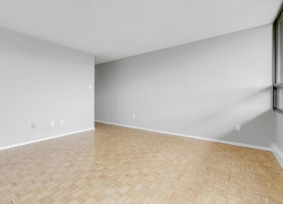 A room with wooden flooring and white walls.