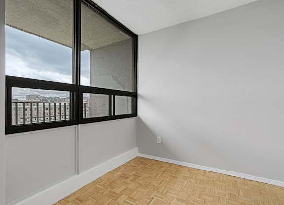 A room with a window and a wooden floor.