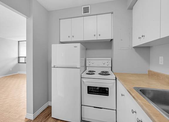 A kitchen with white appliances and cabinets.