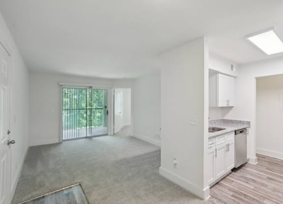 A spacious, empty room with a sliding glass door leading to a backyard.