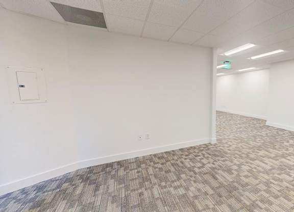 A room with a carpeted floor and white walls.