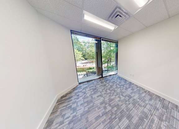 A room with a carpeted floor and a sliding glass door.